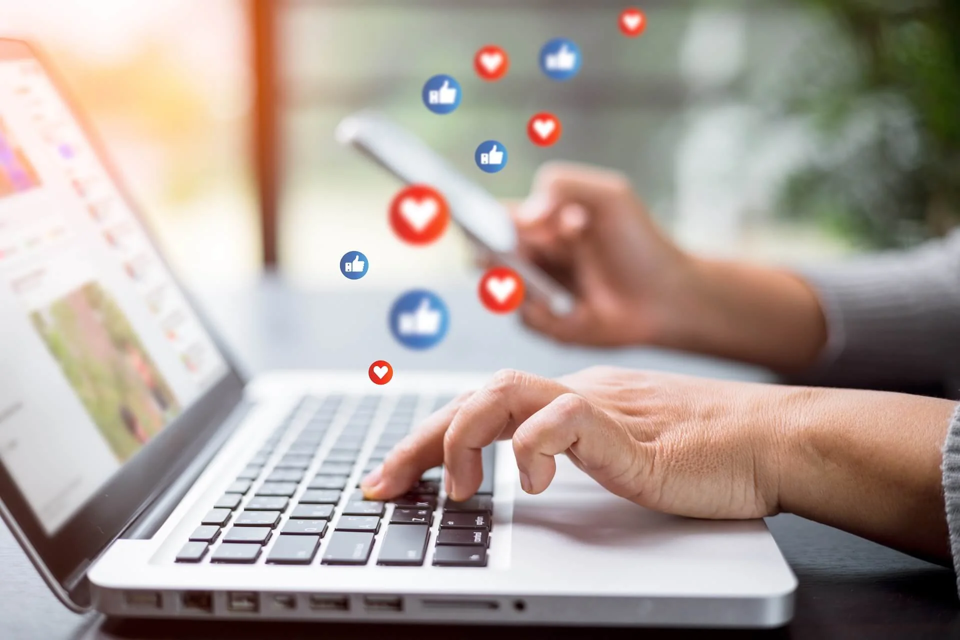 Laptop screen with hands working on dental social media marketing