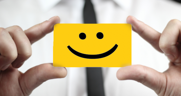 friendly dental marketing professional holding up smiley card